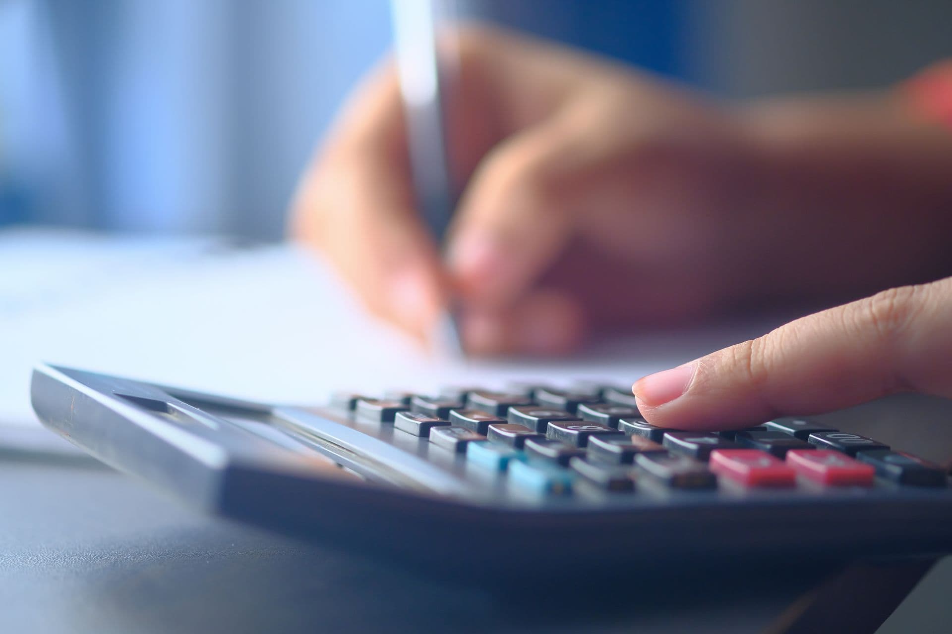 Main sur une calculatrice, préparation d’un budget