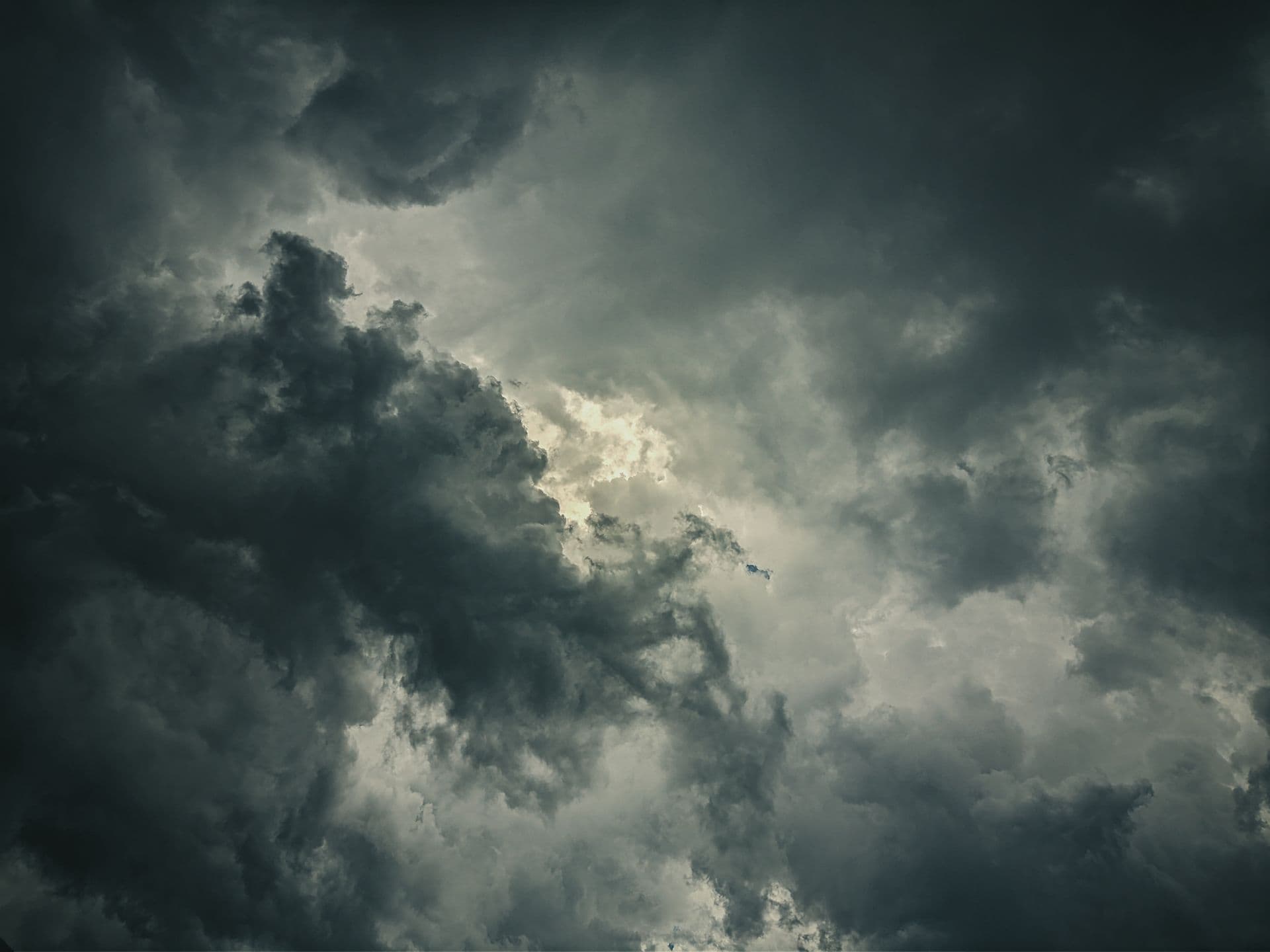 Ciel d’orage aux nuages sombres traversés d’une trouée de lumière