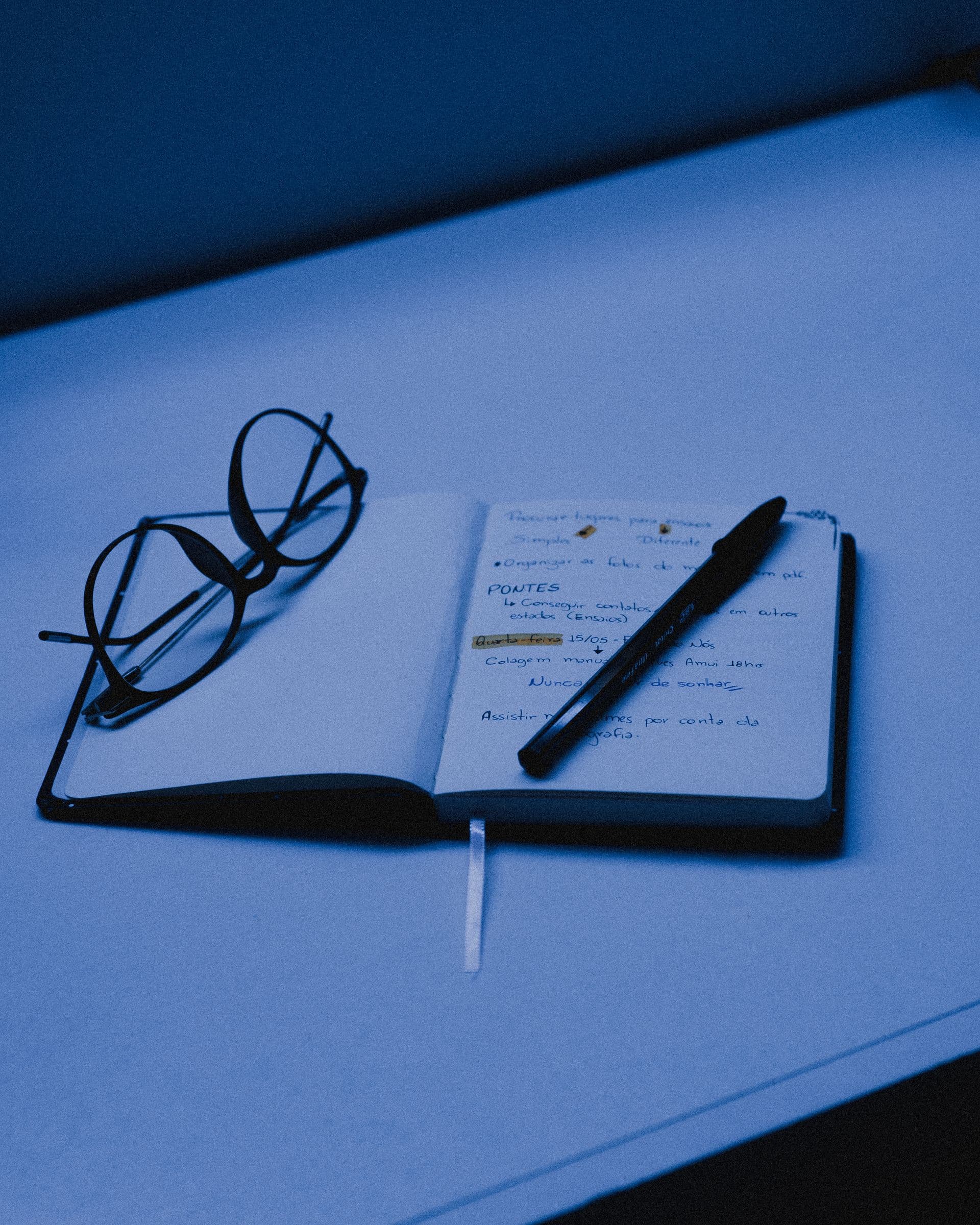 Carnet de notes ouvert et lunettes posées sur un bureau
